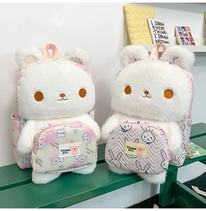 Detail of plush white cartoon animal backpacks with pink accessory pouches on a bench