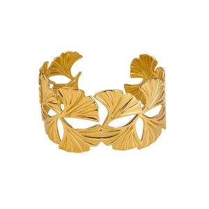 Detailed close-up of hollowed-out ginkgo leaf design on a gold-plated cuff bracelet