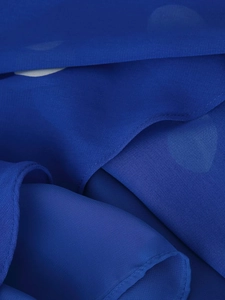 Vue détaillée de la texture du tissu mousseline bleu foncé avec pois et bords ourlés