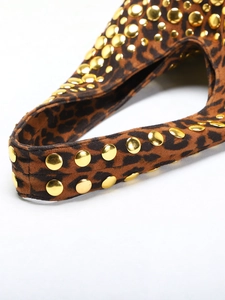 Detail view of gold round rivets and leopard print texture on a punk style shoulder bag