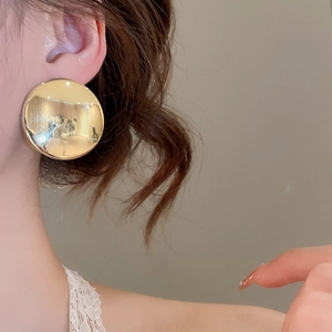 Gros plan détaillé d'un mannequin portant des boucles d'oreilles rondes dorées