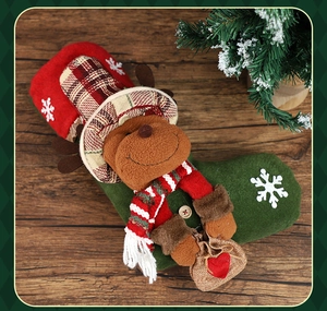 Detail of a green Christmas stocking with a plush reindeer and snowflake embroidery