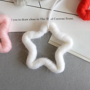 Detailed view of handmade plush wool felt star ornaments with soft fuzzy textures