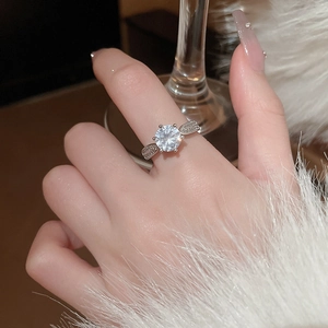 Detail of silver snowflake rotating ring with zircon stones on a model's finger