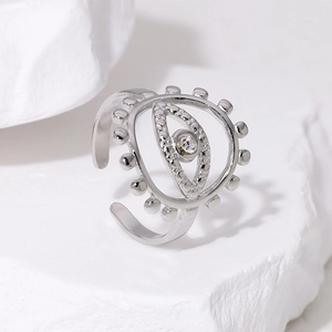 Adjustable silver evil eye ring with sparkling zircon stone on a white stone background