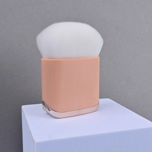 Detailed macro view of a pink square handle makeup brush with white flame-shaped bristles