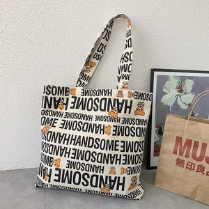 Detail view of large canvas tote bag with Handsome lettering and bear illustration