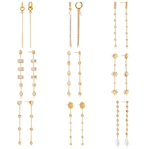9 paia di orecchini a nappa placcati in oro 18K con zirconi, perle e stelle su sfondo bianco