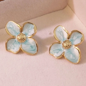 French vintage light blue flower stud earrings with gold trim on pink velvet background