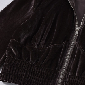 Detail eines kaffeebraunen Samt-Hoodies mit Metallreißverschluss und elastischem Saum