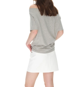 Rear view of loose gray off-shoulder T-shirt paired with white A-line skirt