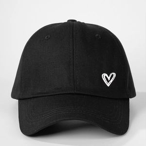 Détail de l'imprimé cœur blanc et des coutures sur cette casquette de baseball en coton noir