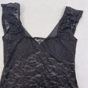 Vue détaillée de la broderie en dentelle noire avec texture ajourée et col en V