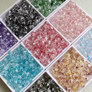 Close-up of assorted 8-10mm colorful glass beads organized in a white storage tray
