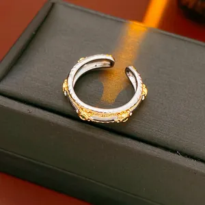 Vintage oval open ring with gold relief and green gems on a black luxury box