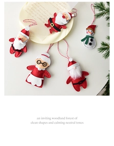 Flat lay of handmade felt Christmas ornaments with Santa and Snowman on a white plate
