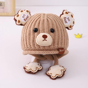 Detail of light brown knitted baby bear hat with cute 3D ears and paw-shaped earflaps
