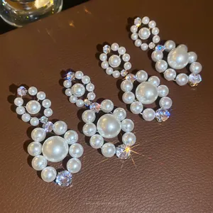 Boucles d'oreilles vintage en perles et zircons scintillants sur cuir foncé