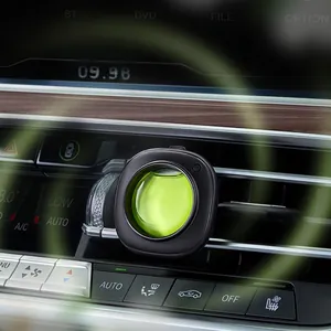 Car air vent clip freshener with green liquid fragrance in a black square case on vent