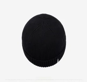 Top view of a black knitted beanie showing six-panel crown stitching and ribbed texture