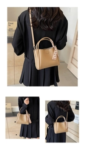 Detail of beige litchi grain bucket bag with silk scarf handle and crossbody strap