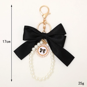 Black ribbon bow keychain with pearls and gold-tone charms, length 17cm and weight 25g