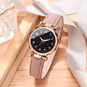 Detail of rose gold star dial watch with faceted glass lens and pink matte strap