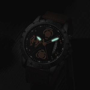Luminous hands and hour markers glowing in the dark on a black quartz watch face
