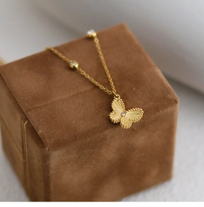 Macro view of golden butterfly pendant with radial texture and beaded edges on velvet
