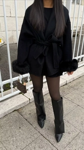 Detail of wool coat with thick black faux fur cuffs and elegant street style fashion outfit