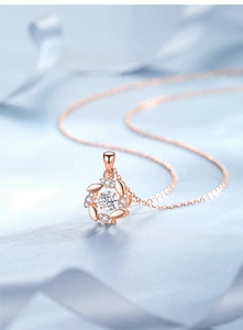Macro shot of rose gold lucky wheat ear necklace with sparkling moissanite on silk