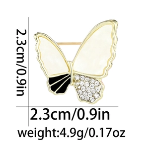 Detailed size view of a butterfly brooch with white enamel wings and sparkling rhinestones
