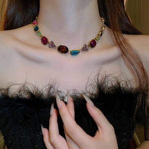 Macro detail of vintage necklace with red blue green gems on model neck