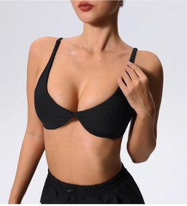 Detail of black ribbed sports bra featuring thin straps and twisted front center knot