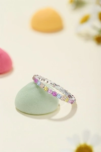 Macro shot of S925 sterling silver ring with colorful zircons on a green stone