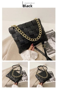 Detail of black woven leather handbag with chunky gold chain and textured finish