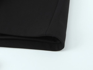 Nahaufnahme der schwarzen Webstofftextur mit detaillierter Saumnaht am Midikleid