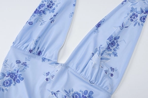 Makro-Detail des V-Ausschnitts und blauer Blumendruck auf dem rückenfreien Sommerkleid