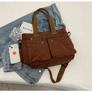 Brown corduroy tote bag detail with dual zipper pockets on a casual denim jacket layout