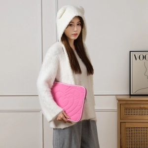 Macro detail of pink quilted heart pattern on tablet sleeve with white piping