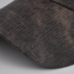 Close-up of vintage plaid baseball cap brim with five-row reinforced stitching detail