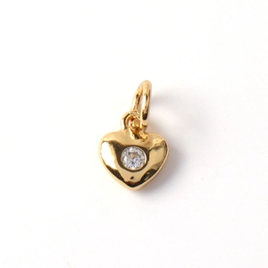 Detail of heart-shaped gold pendant with a central sparkling cubic zirconia stone
