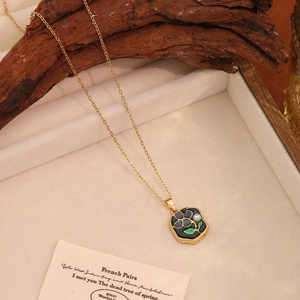 Collier vintage doré français avec pendentif fleur bleue et détail feuille verte sur plateau