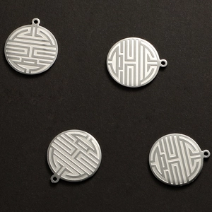 Detailed close-up of four silver stainless steel round pendants with Longevity engraving