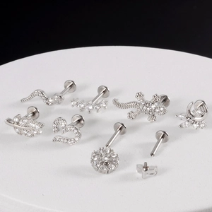 Set of silver stainless steel moon and snake piercing jewelry on white platform