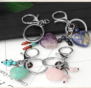 Detail of heart-shaped natural stone keychains with hand-woven tassels and silver clasps