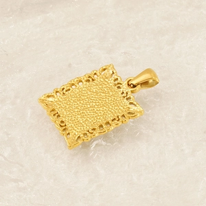 Détail macro du pendentif carré doré avec bords évidés et texture de surface granuleuse