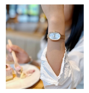 Exquisite women's vintage gold watch with oval dial shown on wrist in a lifestyle setting
