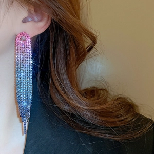 Macro shot of long tassel earrings with pink and blue gradient crystal fringe detail