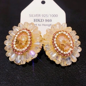 Detailed macro view of S925 sterling silver gold-plated sunflower stud earrings with crystals